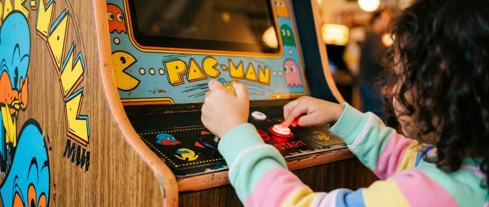 Child-sized hands gripping an arcade joystick